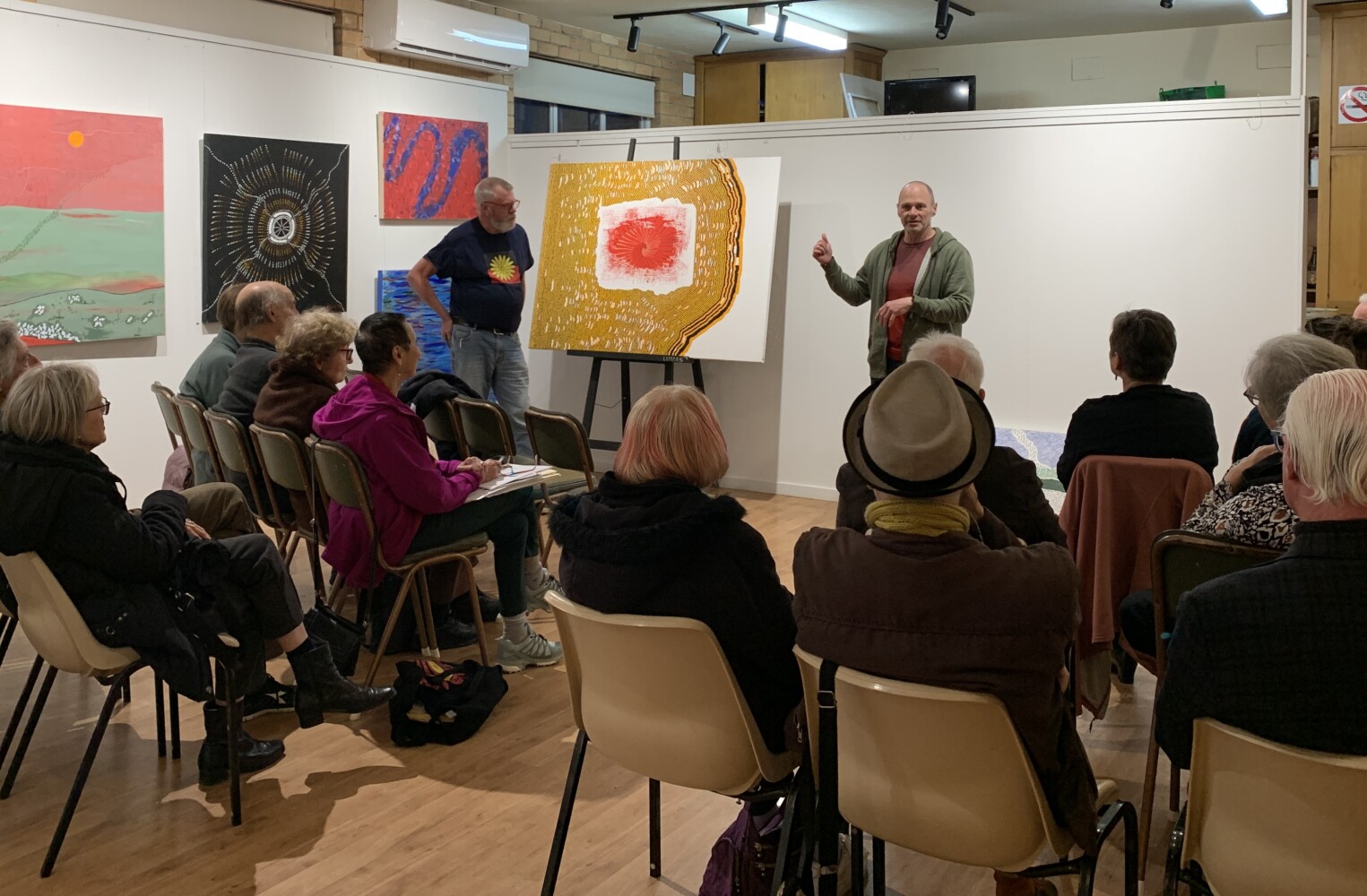 A presentation to a room of people about artwork.